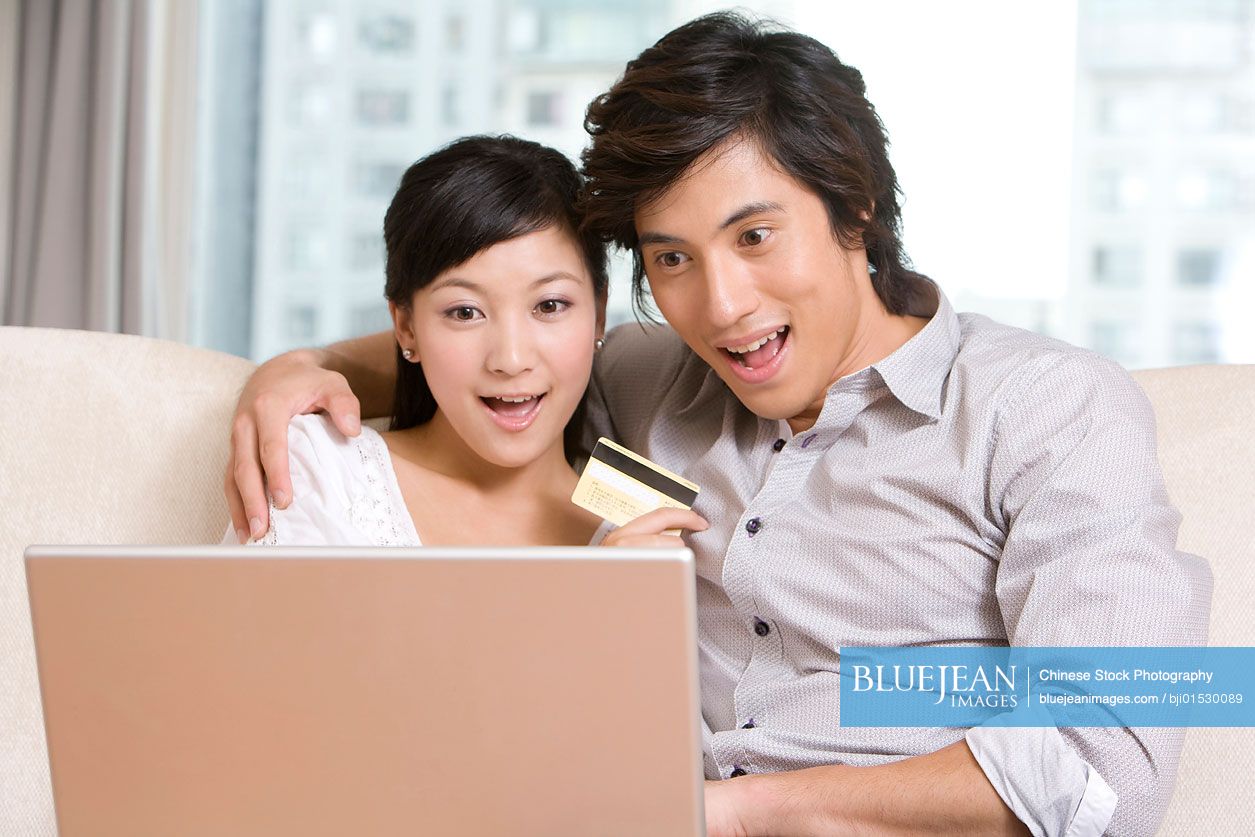 Chinese couple cuddling on a sofa