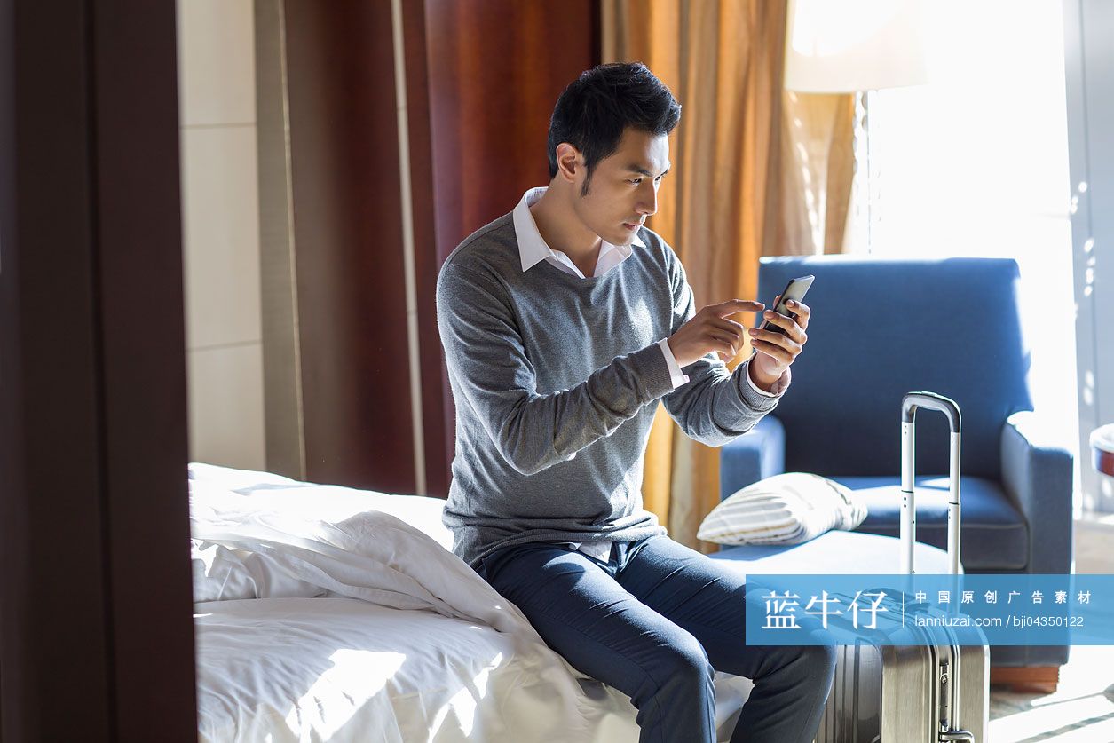 年轻商务男士在宾馆使用手机-蓝牛仔影像-中国原创广告影像素材