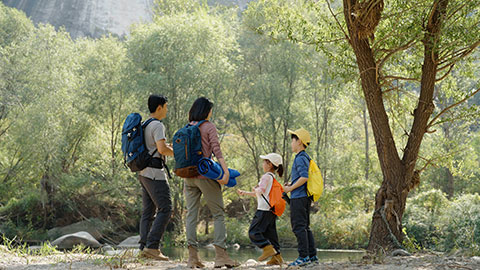 Happy young Chinese family hiking outdoors