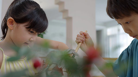 Girl and boy enjoy potting plants together at home