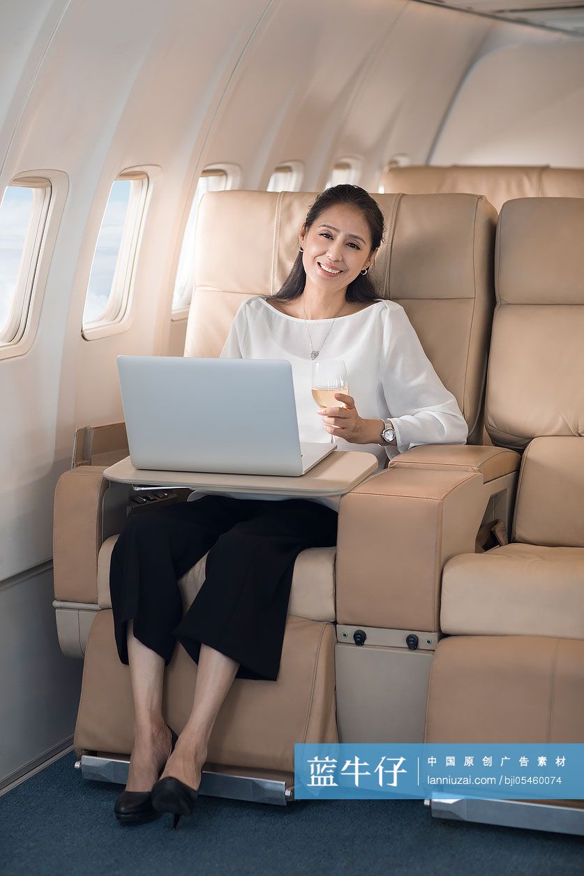 商务女士在机舱里使用笔记本电脑