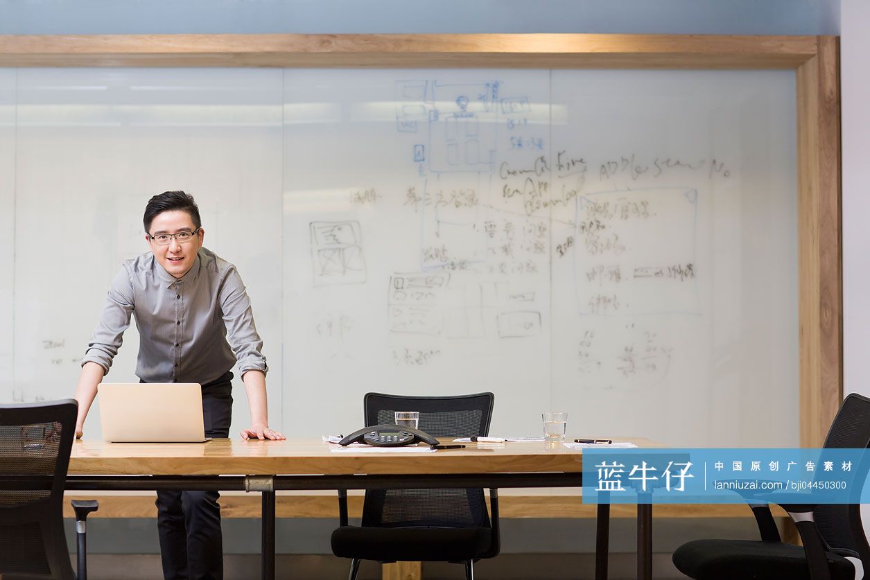 年轻男子在会议室使用平板电脑