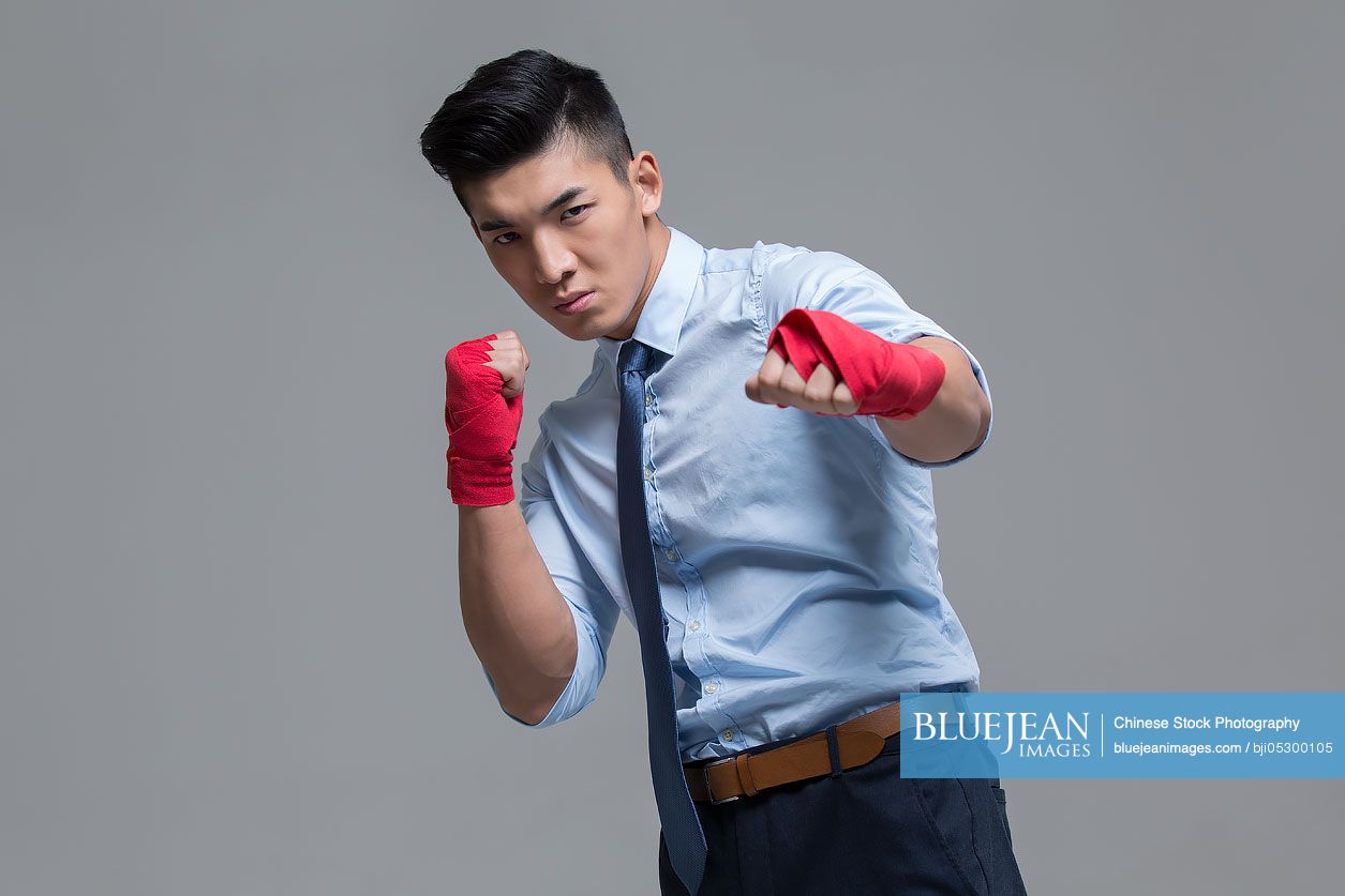 Young Chinese businessman punching