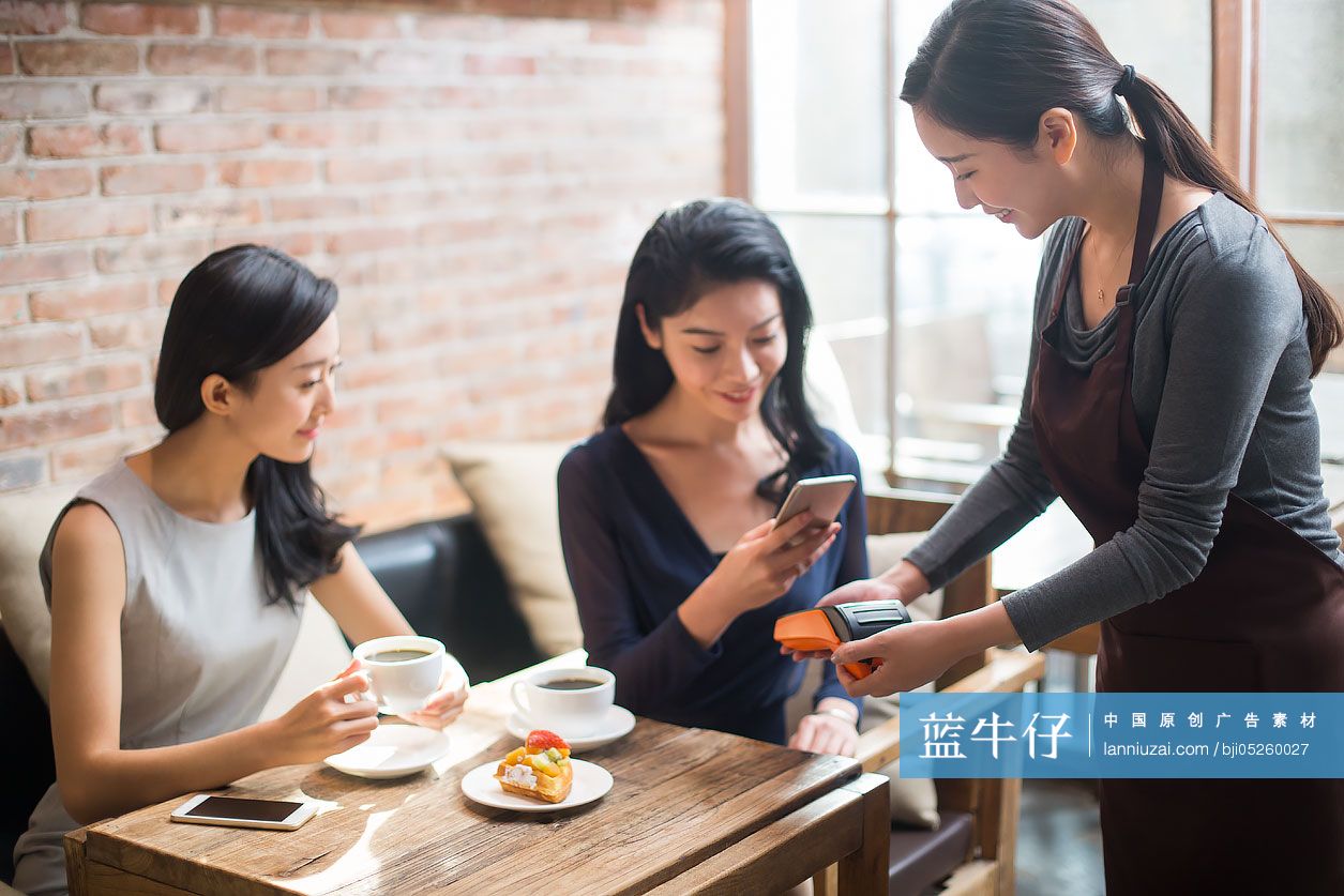 闺蜜俩在咖啡馆用手机结账