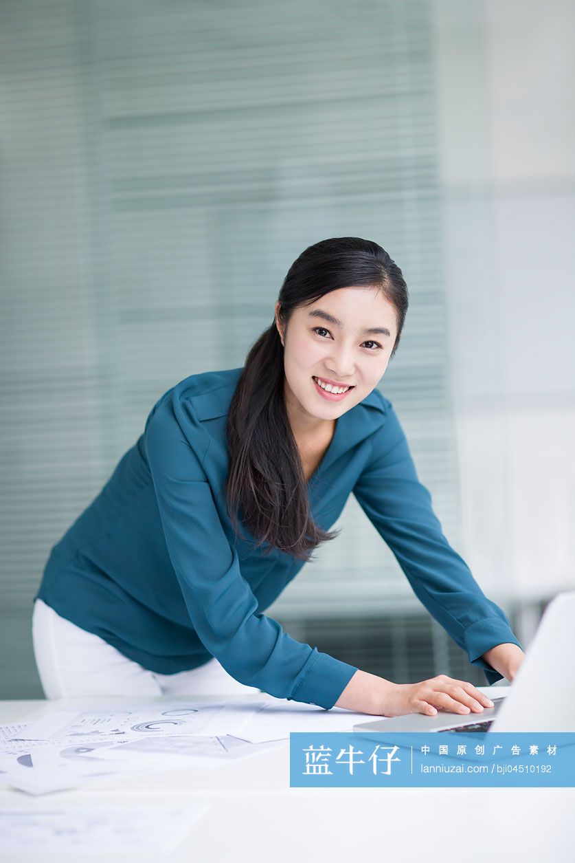 年轻商务女士在办公室使用笔记本电脑