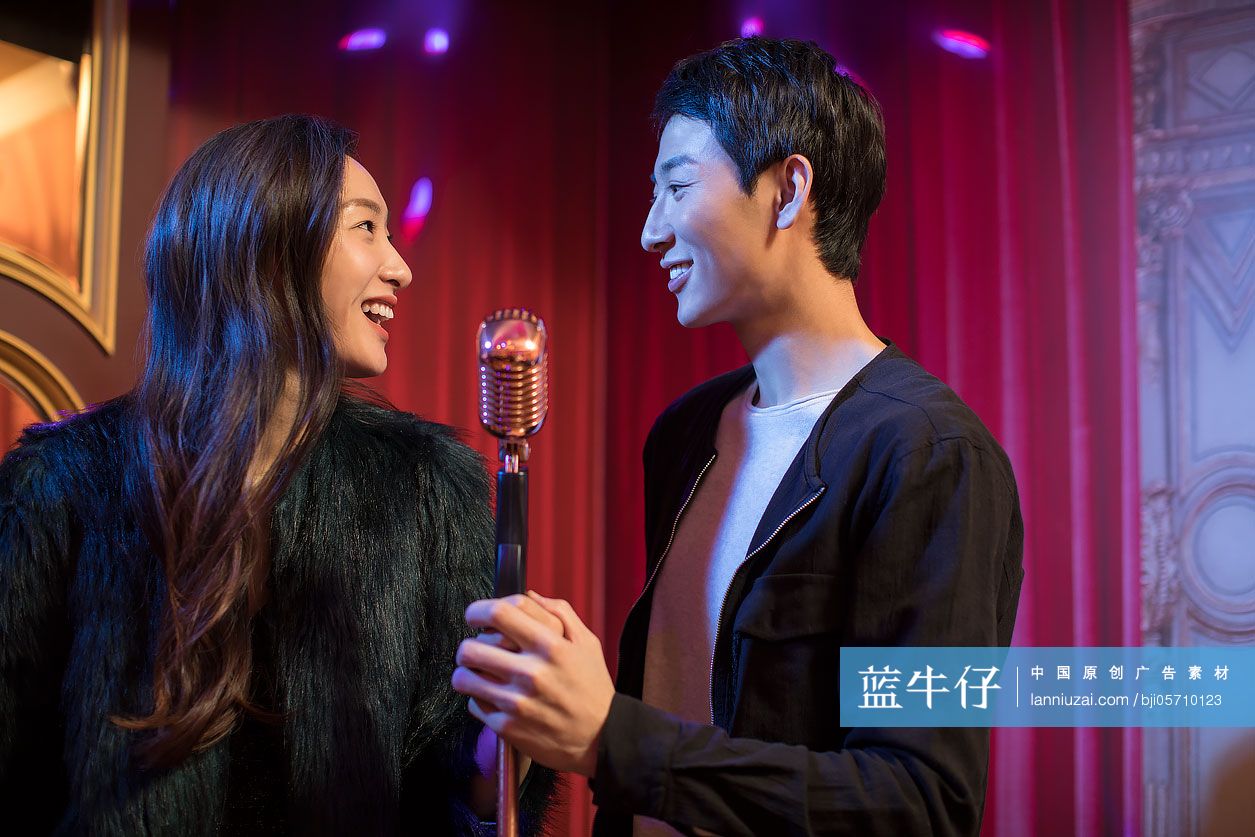 快乐的年轻情侣在KTV唱歌