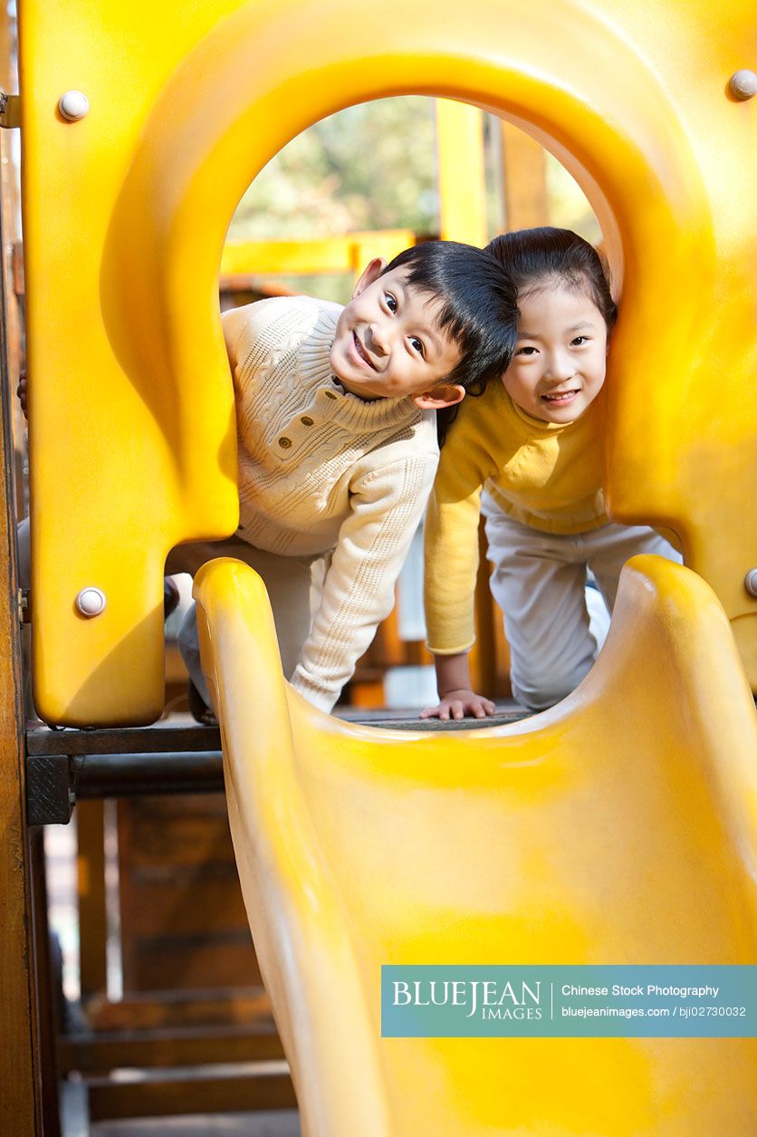 Chinese children playing on playground slide