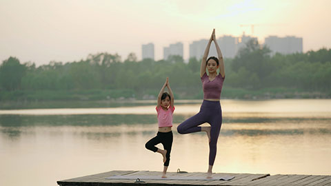 妈妈和女儿在公园练瑜伽