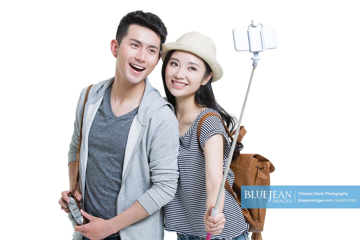 Young Chinese couple taking self portrait with a smart phone