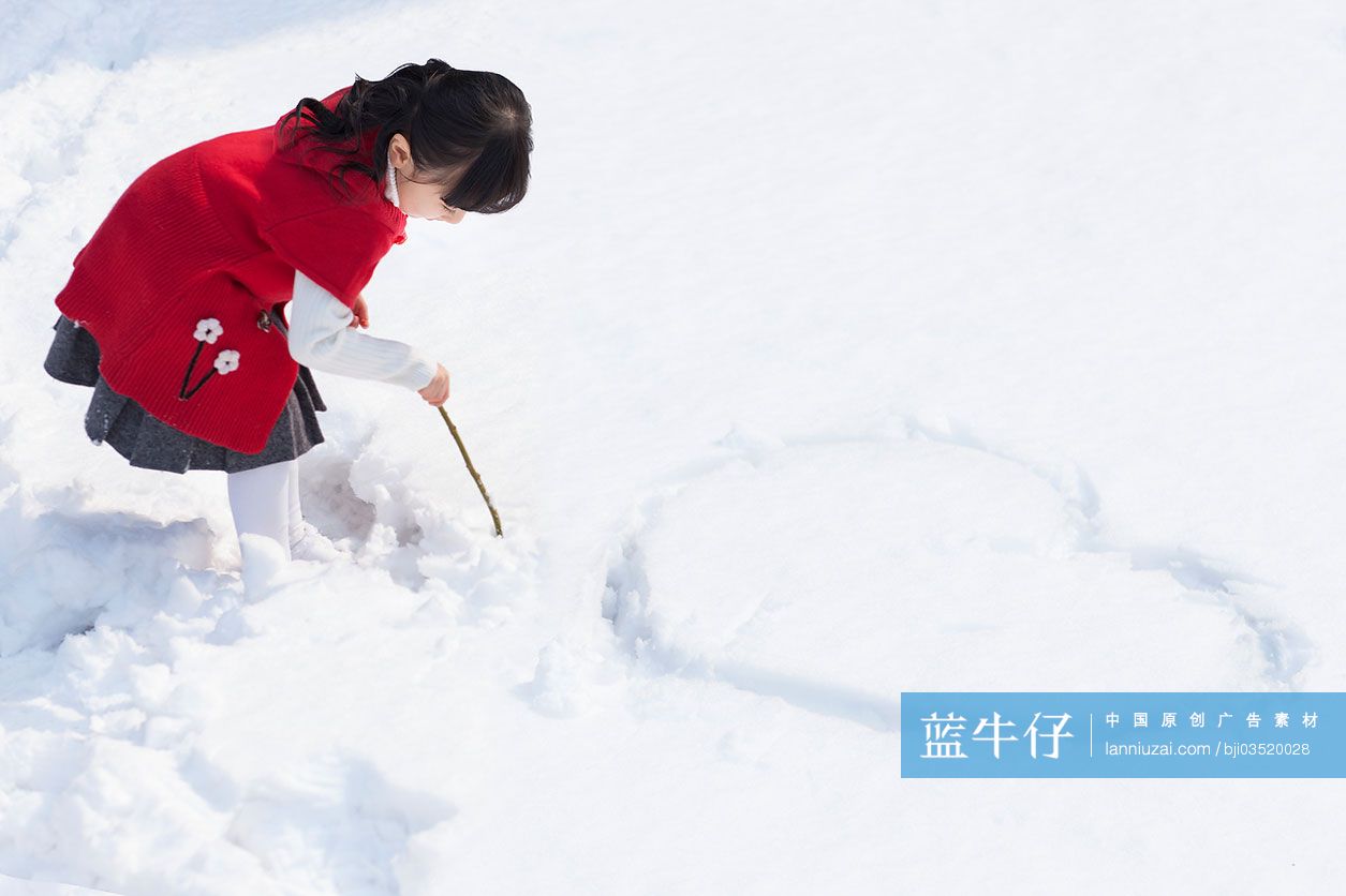 小女孩在雪地上画心型图案