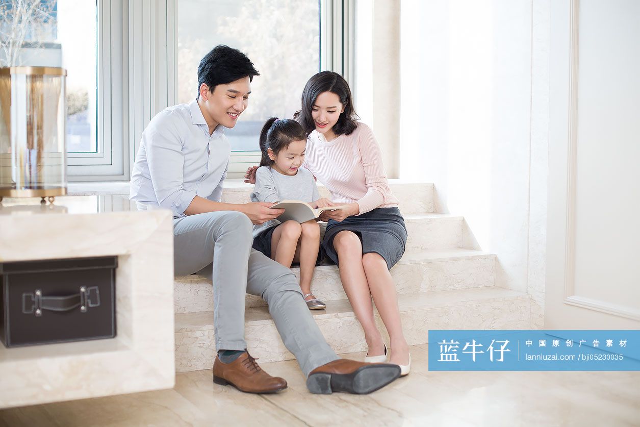 快乐的年轻家庭在客厅看书