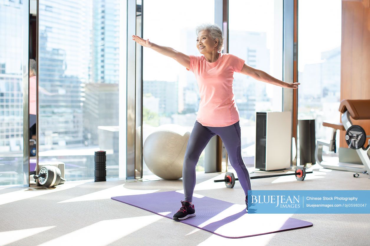 Senior Chinese woman exercising at gym