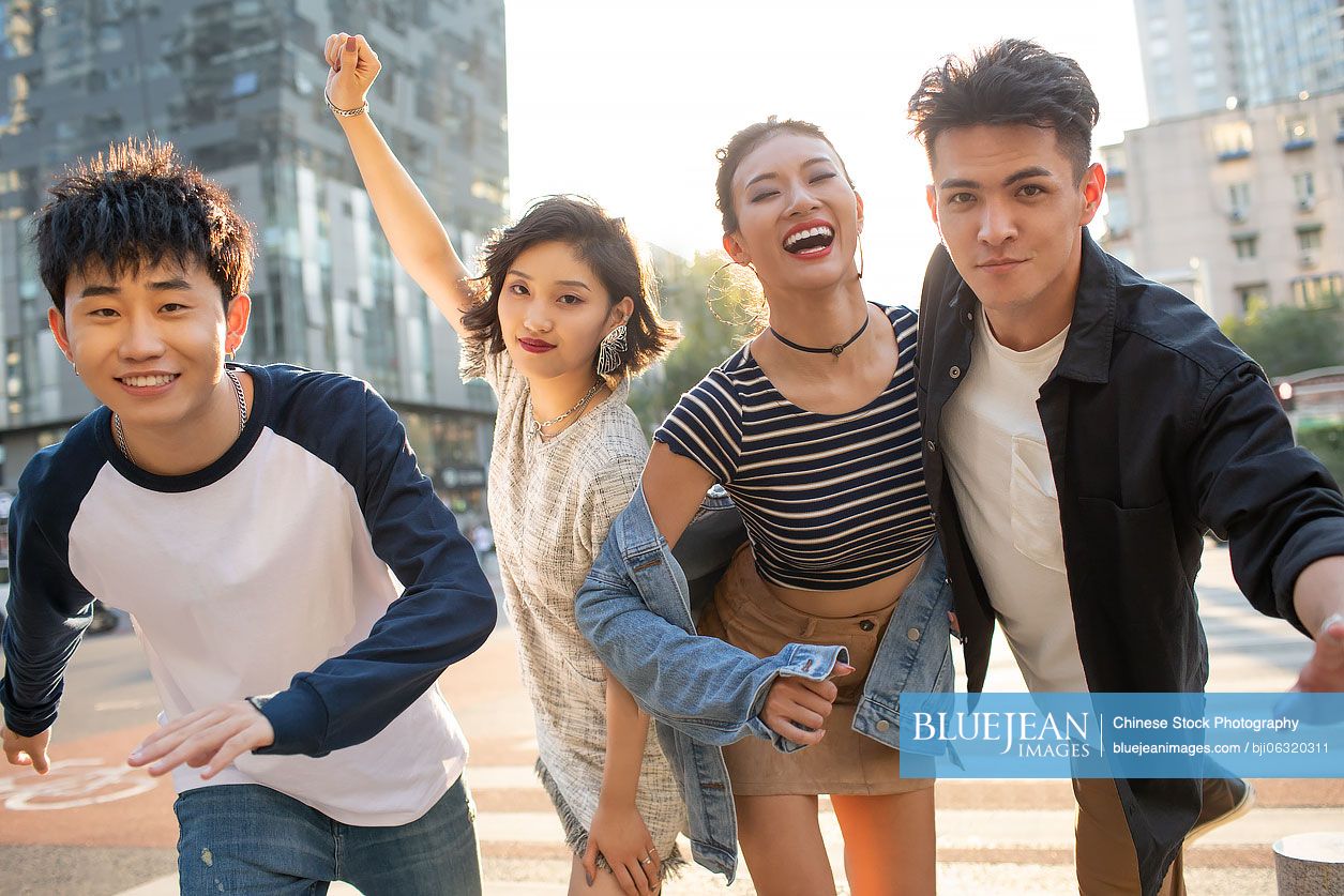 Fashionable young Chinese friends having fun on street
