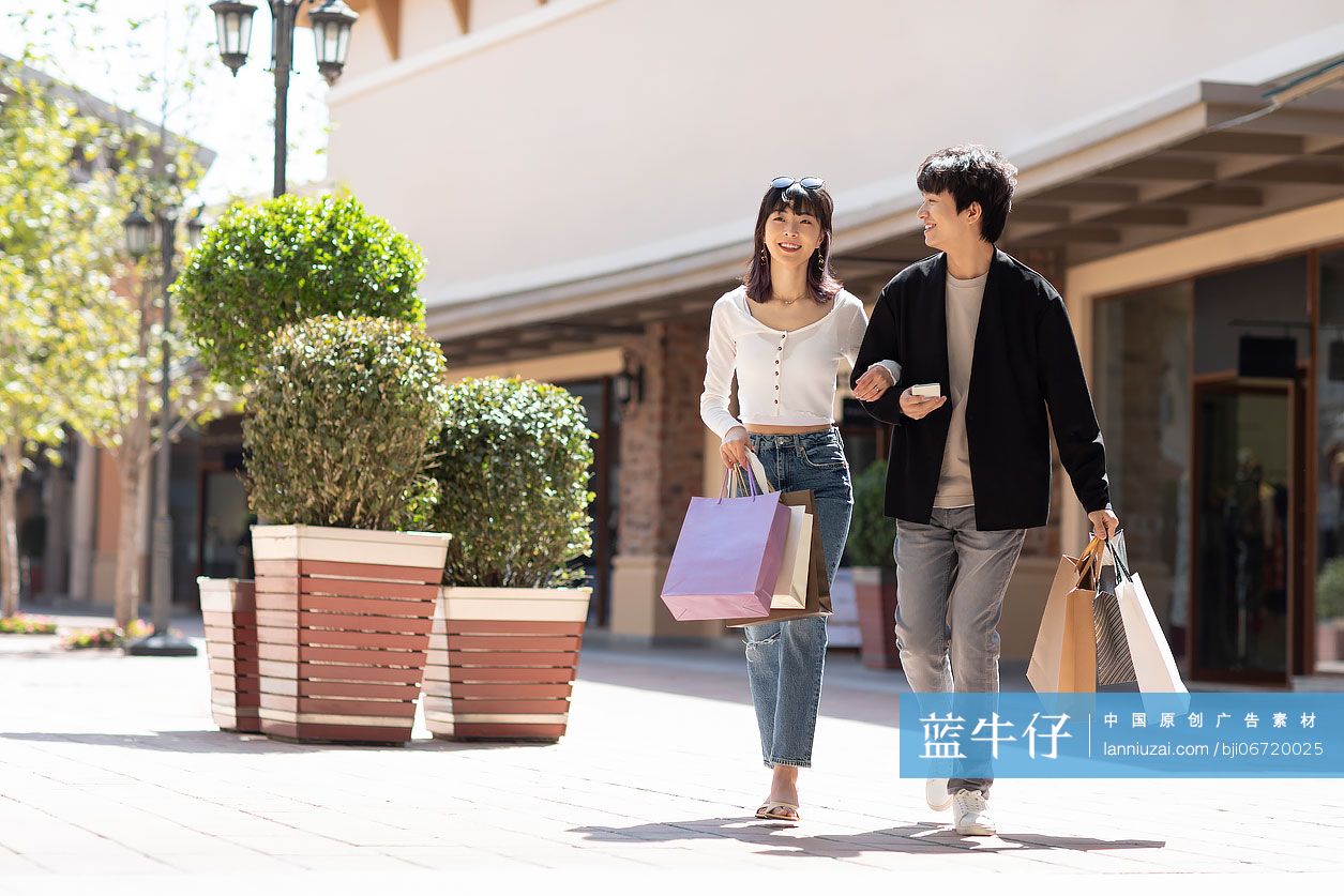 快乐的年轻情侣逛街购物