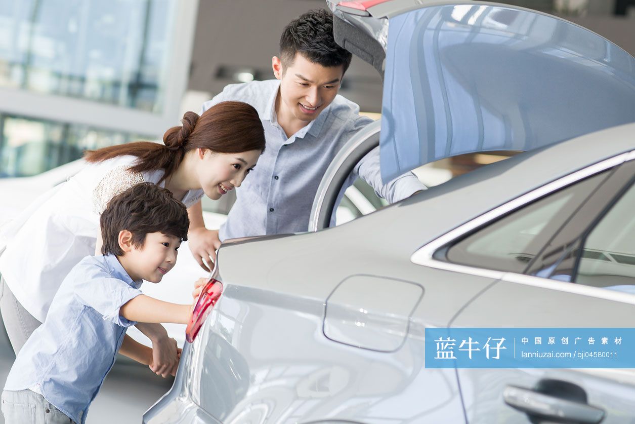 年轻家庭在4S店挑选汽车