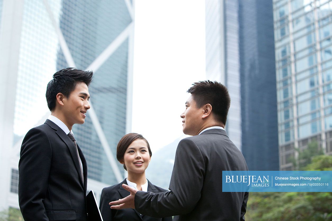 Cheerful Chinese Business Persons Discussing With Each Other In Hong