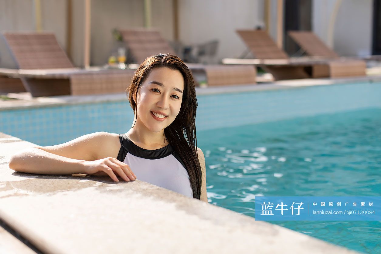 快乐的年轻女子在泳池边休息