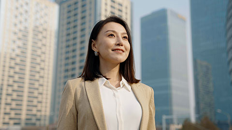 Confident Chinese businesswoman standing outdoors