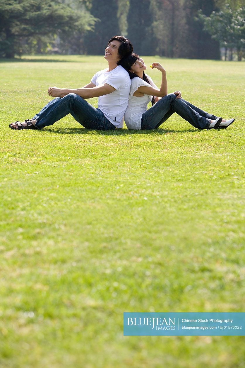 Young Chinese couple sitting outdoors