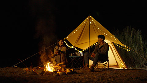 Happy young Chinese couple camping outdoors