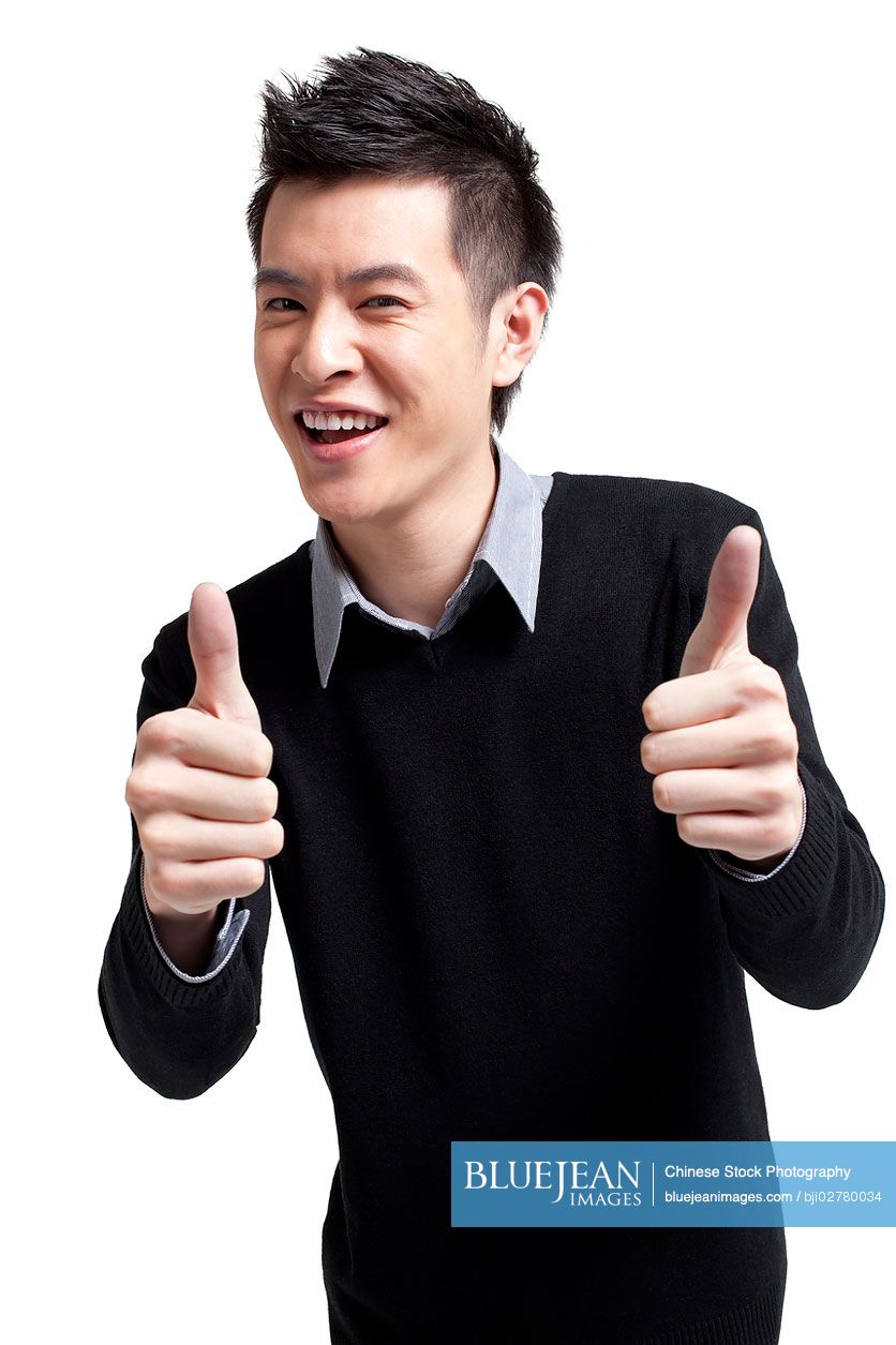 Stylish young Chinese man showing thumbs-up