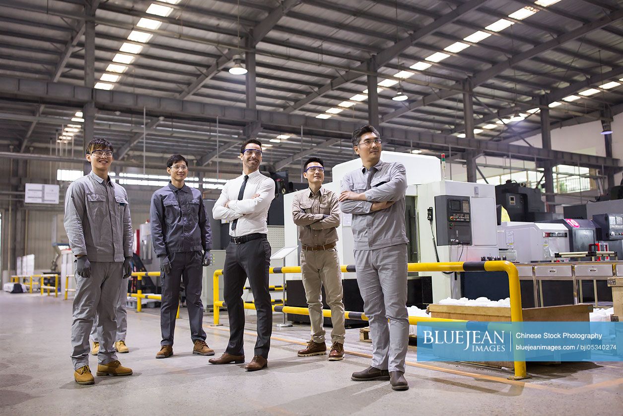 Confident businessman and engineering team in the factory