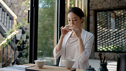 Elegant young Chinese woman drinking tea in tea room,4K