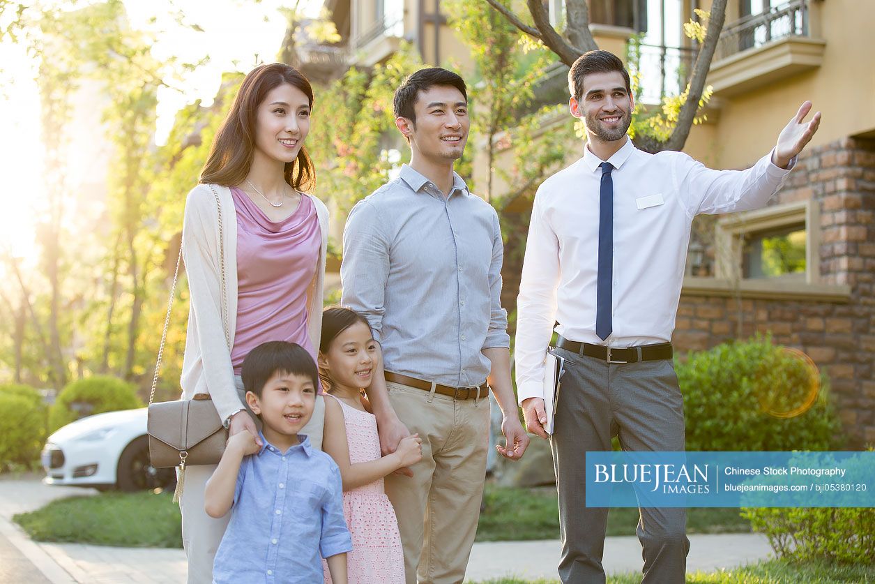 Happy young Chinese family and real estate agent