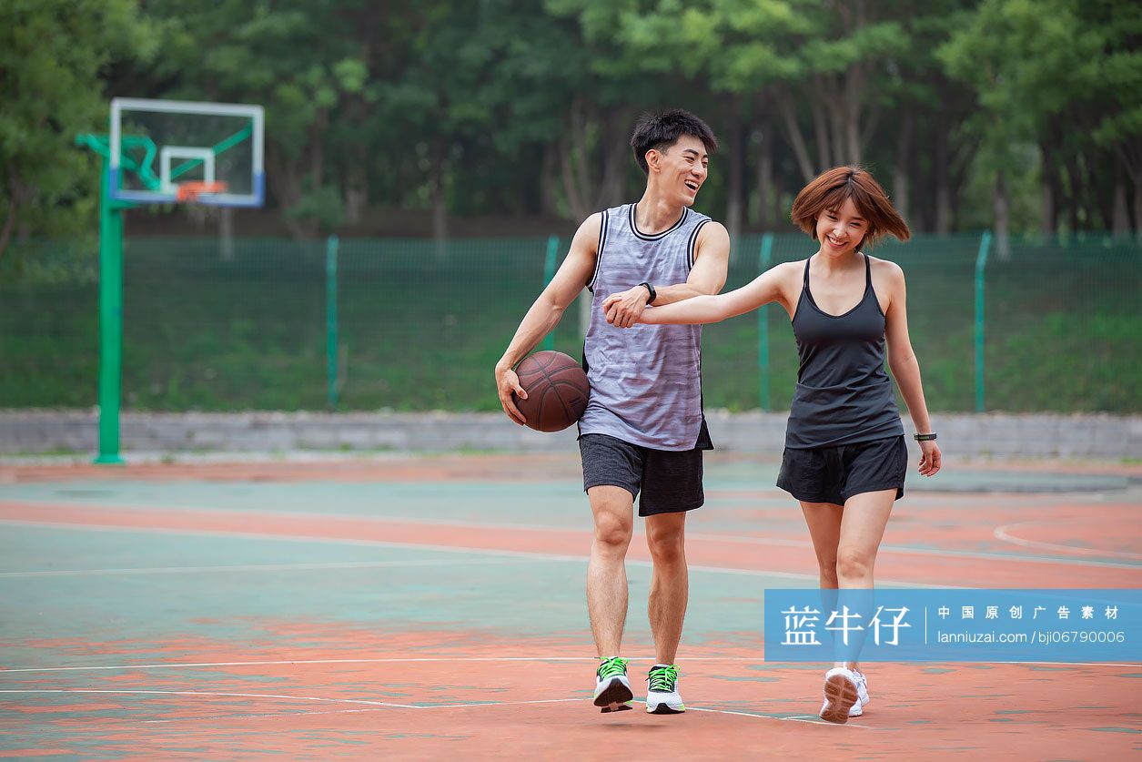 开心的年轻情侣在篮球场打篮球-蓝牛仔影像-中国原创广告影像素材