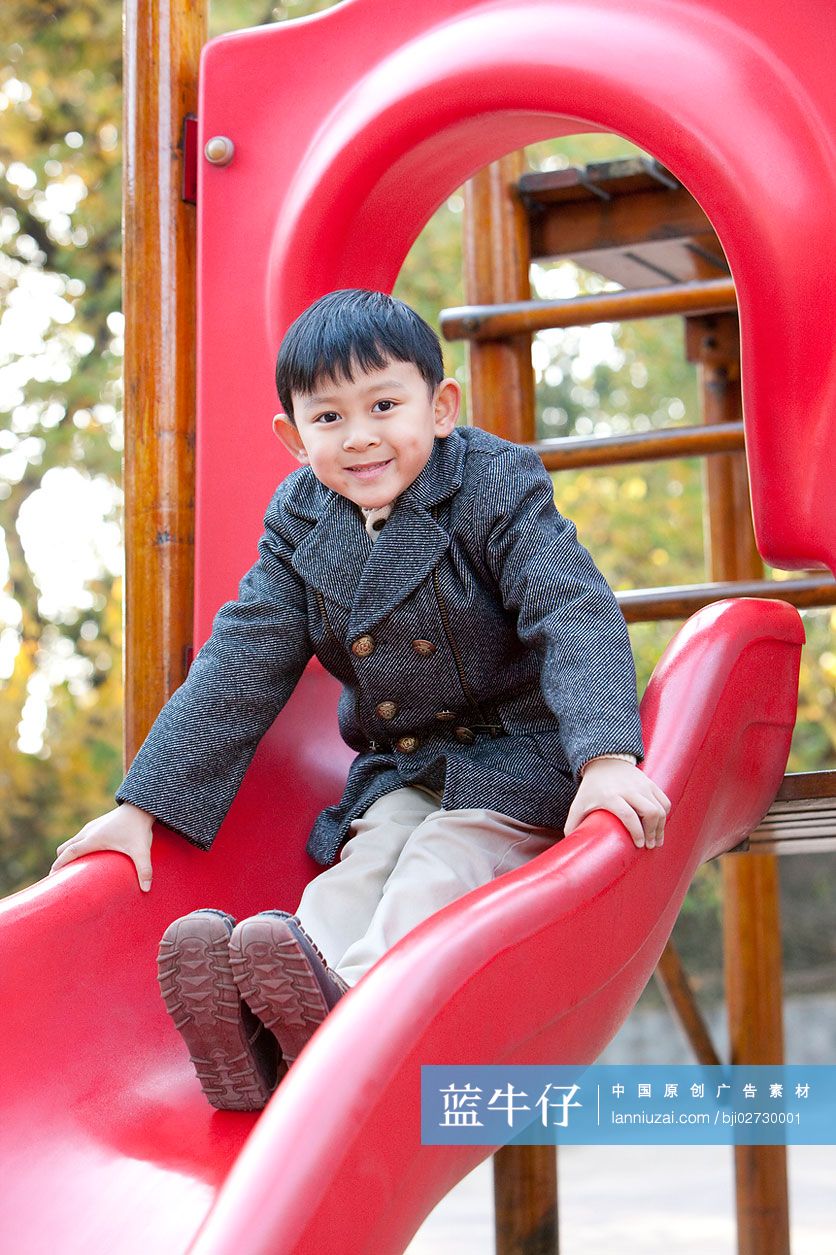 小男孩在公园玩滑梯