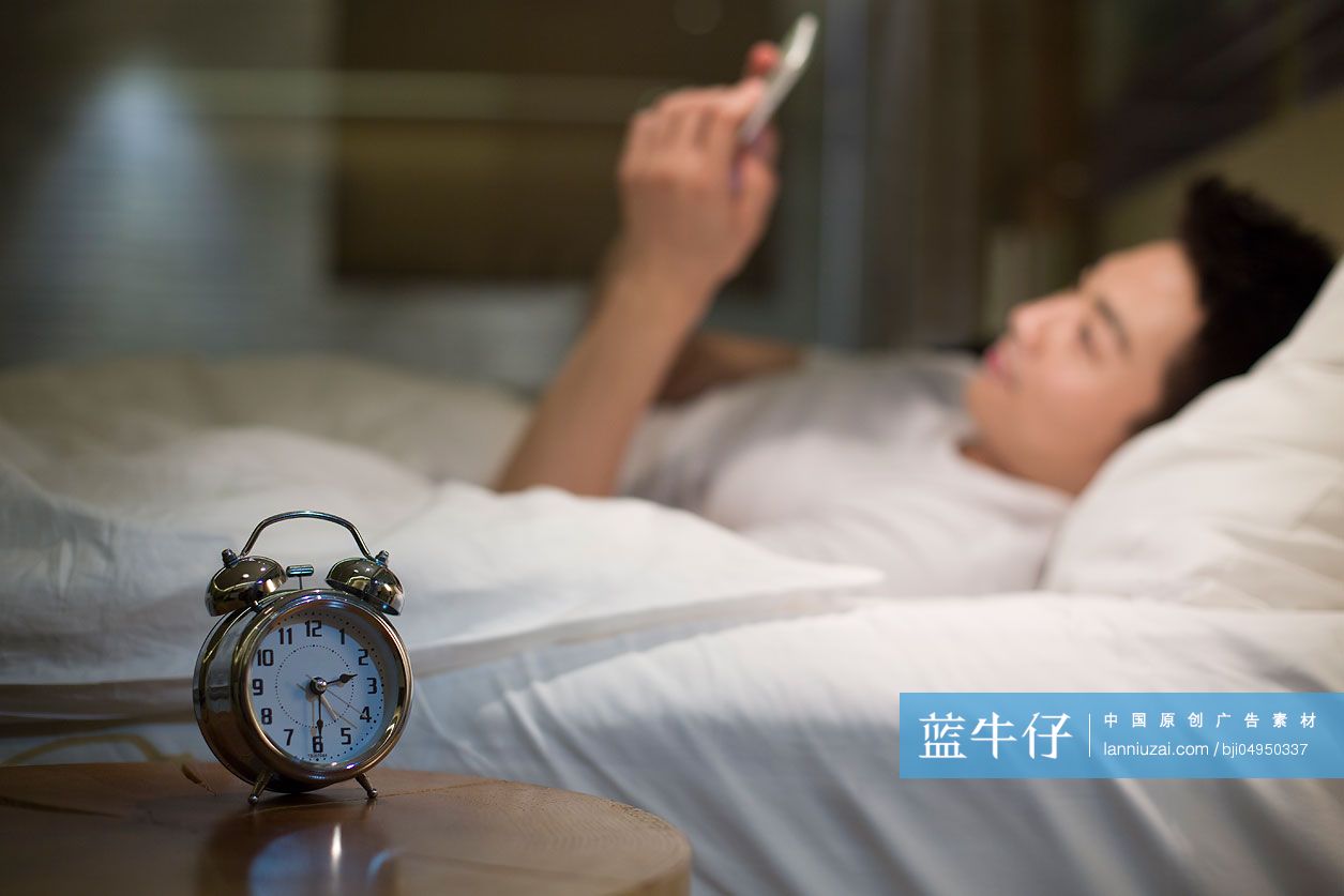 年轻男子在床上玩手机-蓝牛仔影像-中国原创广告影像素材
