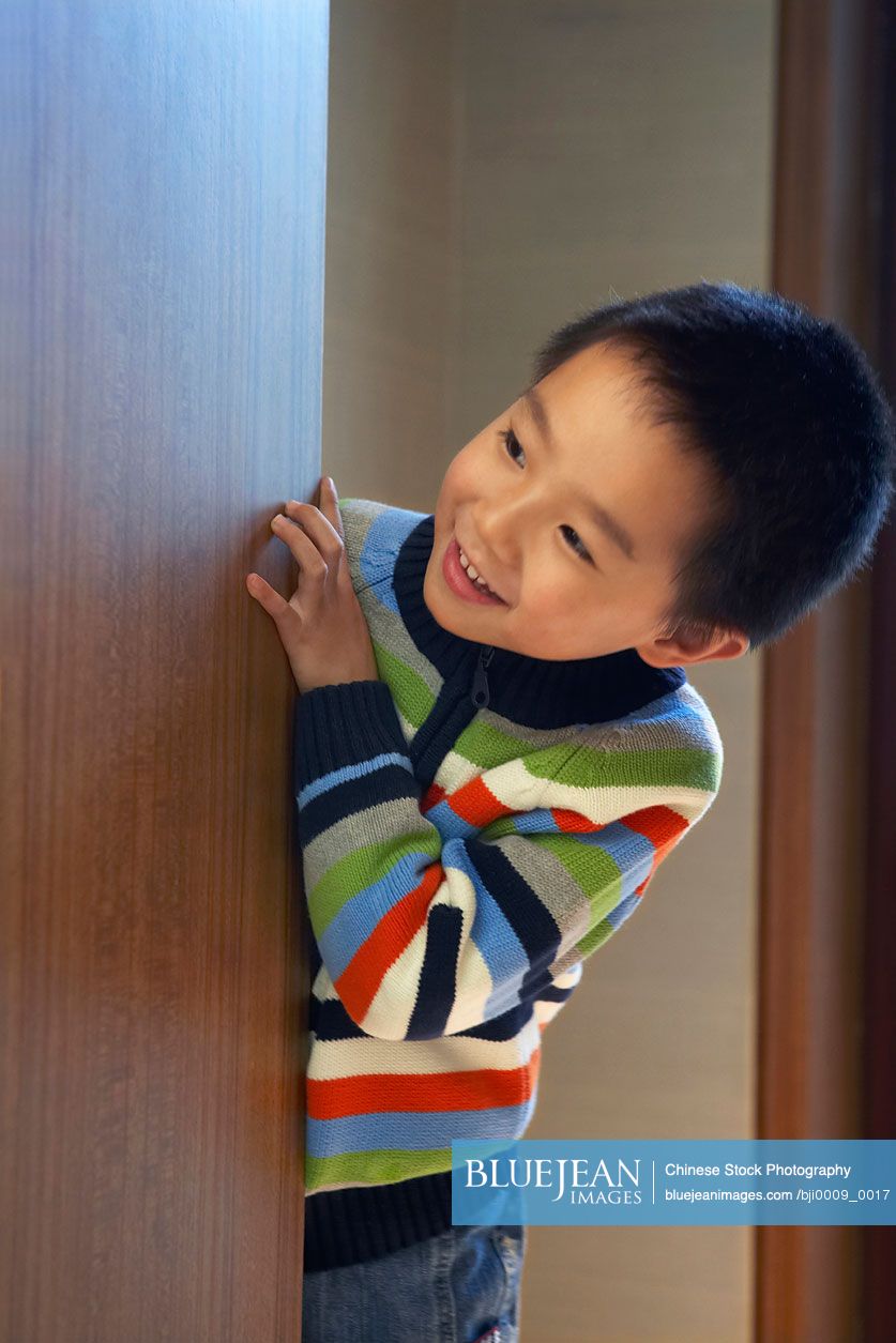 Chinese Boy Looking Around Door