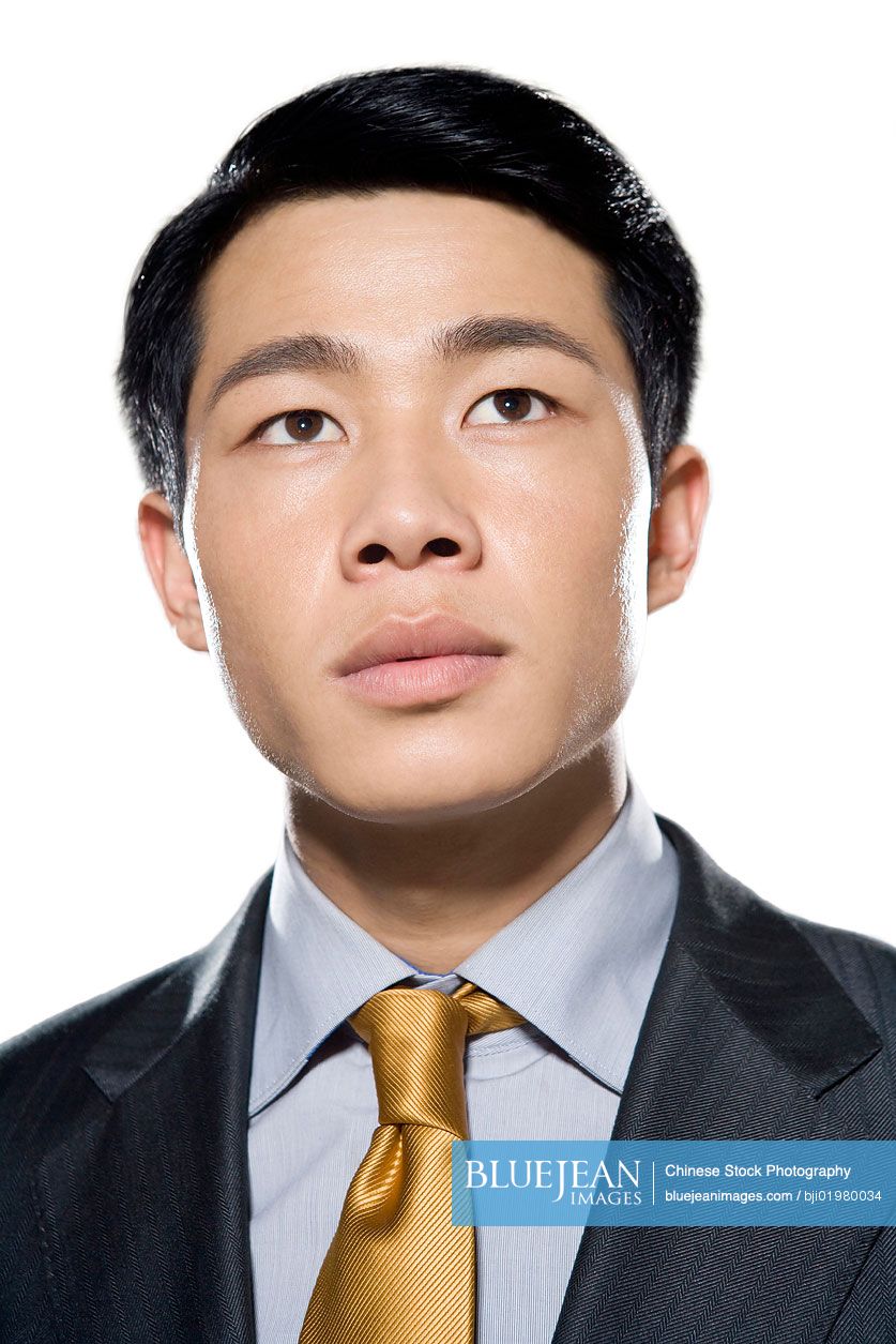 Portrait of Chinese businessman looking up on white background