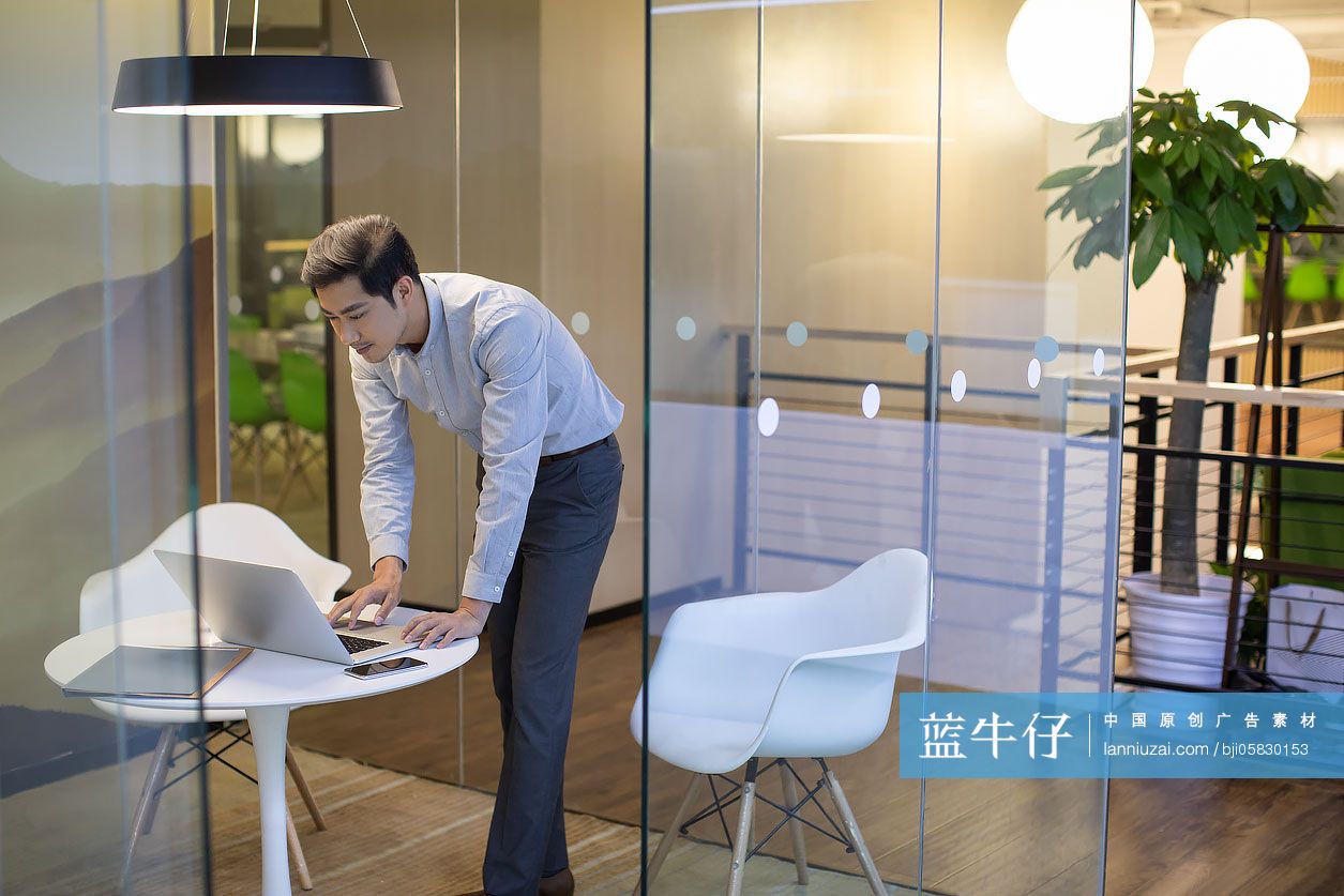 自信的商务男士在办公室使用电脑