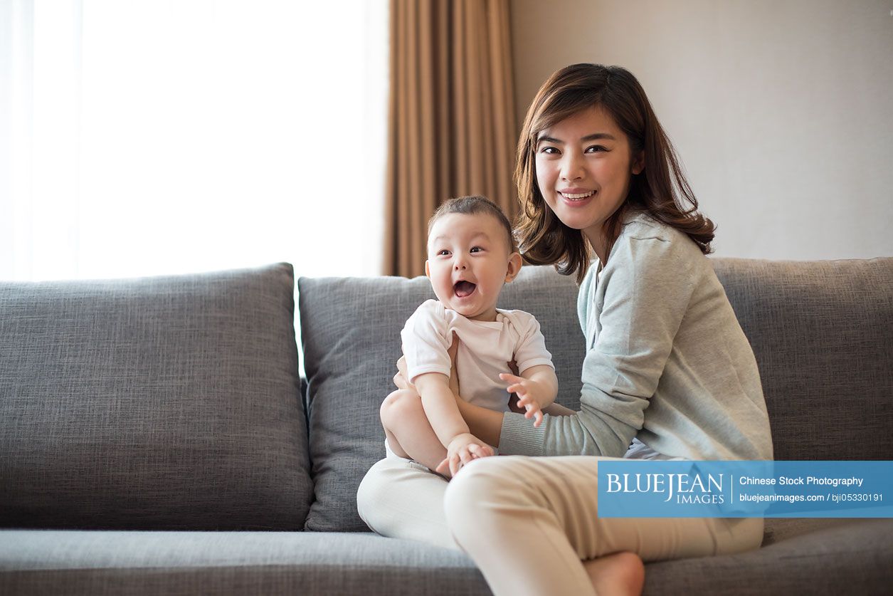 Happy Chinese mother and cute baby at home