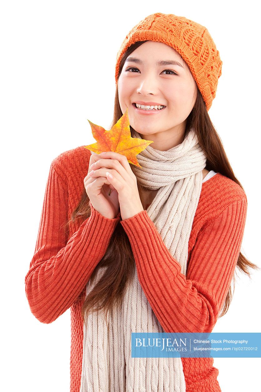 Portrait of young Chinese woman,maple leaf in hand