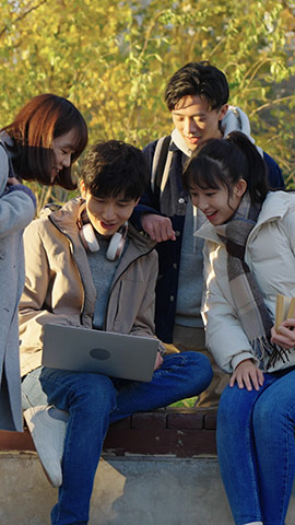 Happy Chinese college students using laptop and discussing,HD