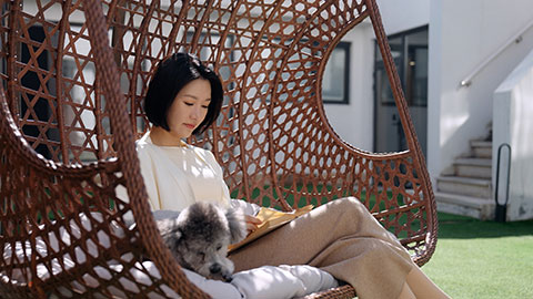 Happy young Chinese woman with pet dog on hanging-chair,4K