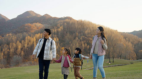 Happy young Chinese family hiking outdoors