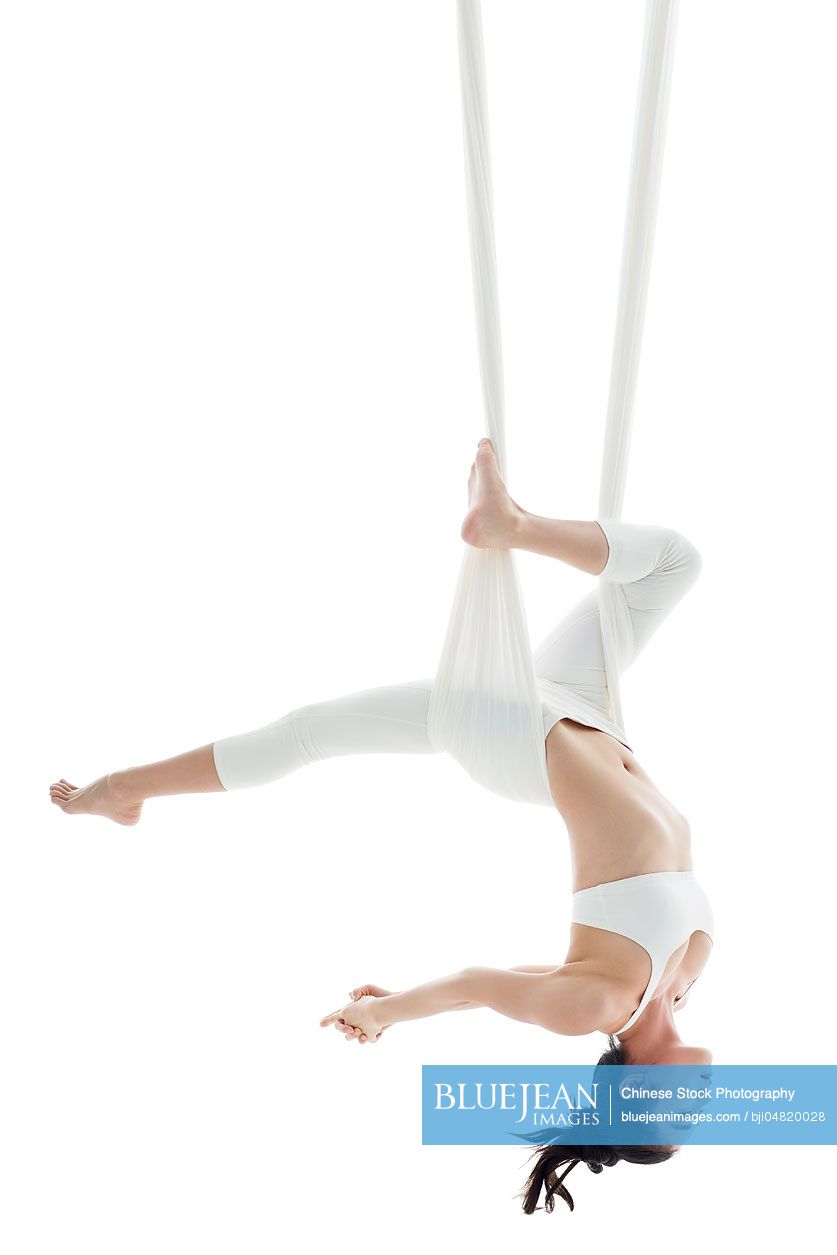 Young Chinese woman practicing aerial yoga