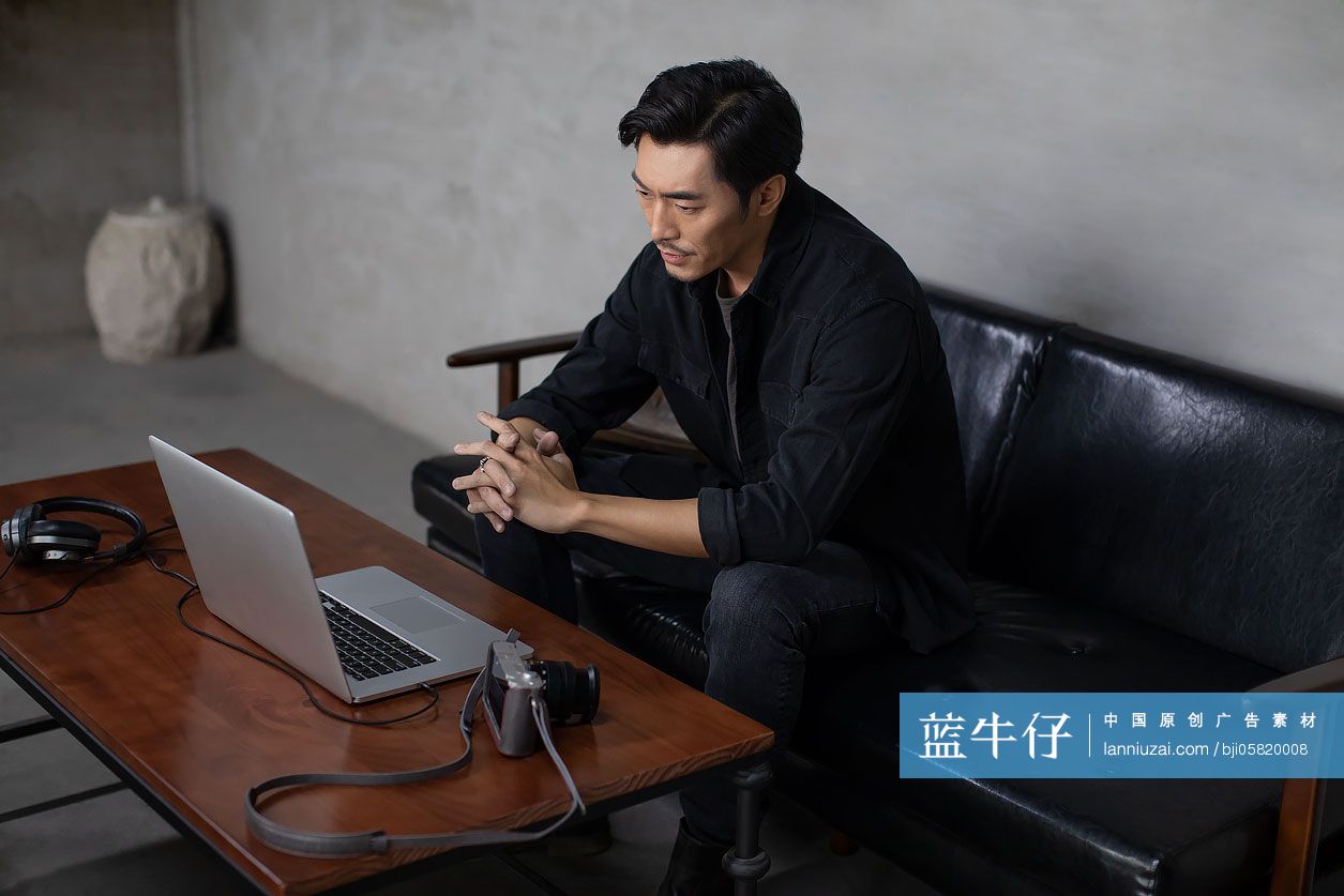 职业摄影师在工作室使用电脑工作