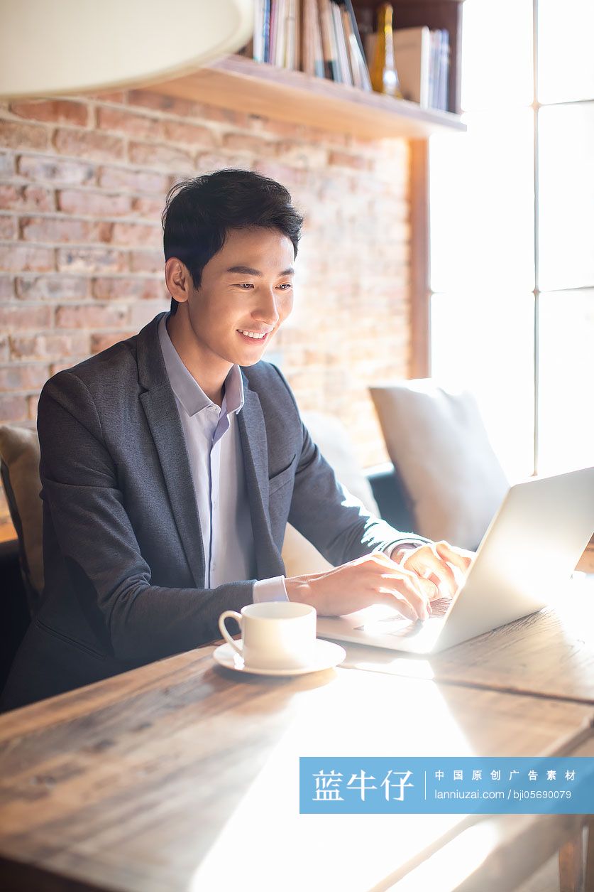 年轻商务男士在咖啡店使用电脑