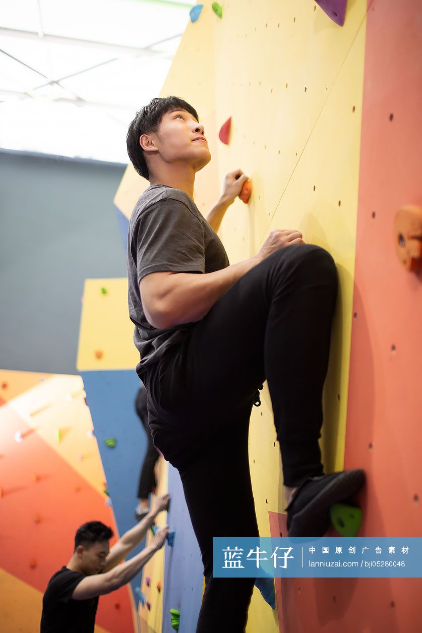 快乐的年轻女孩在健身馆攀岩