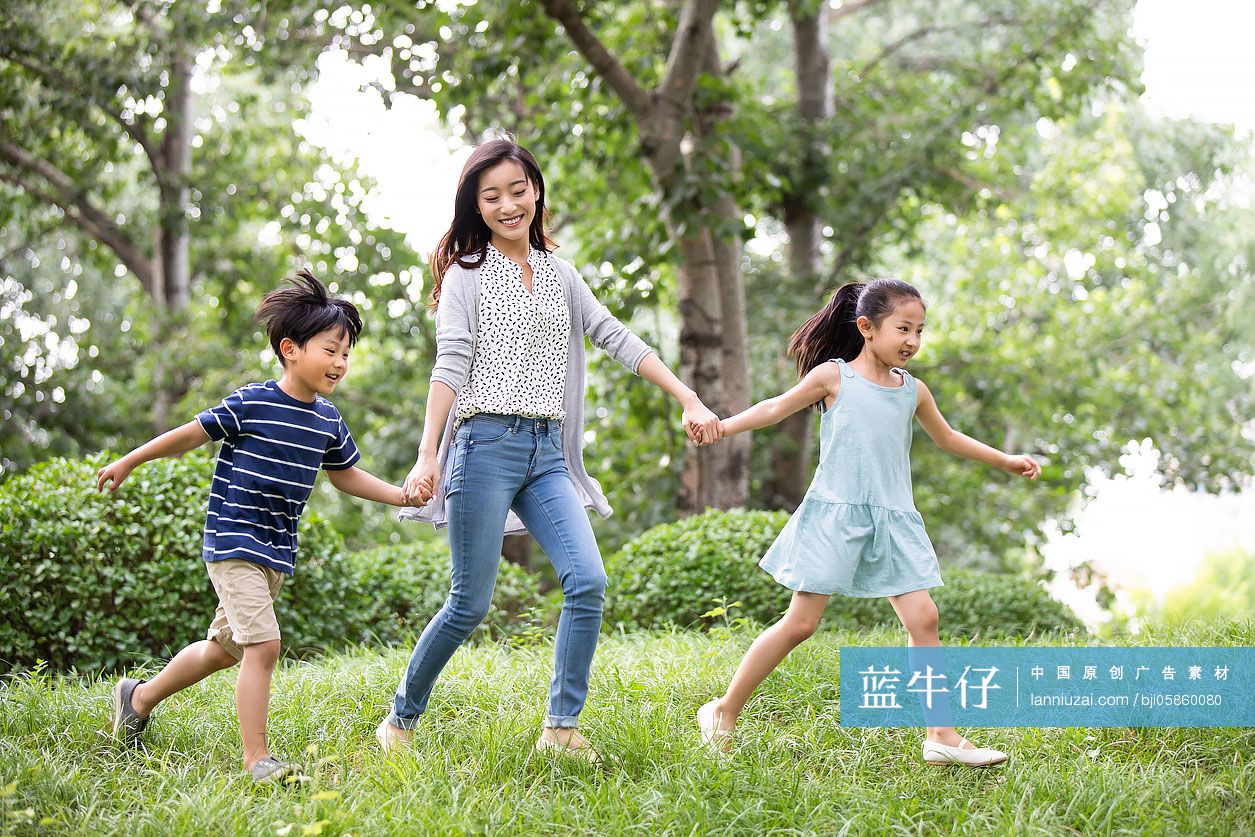 快乐的年轻家庭在草地上奔跑