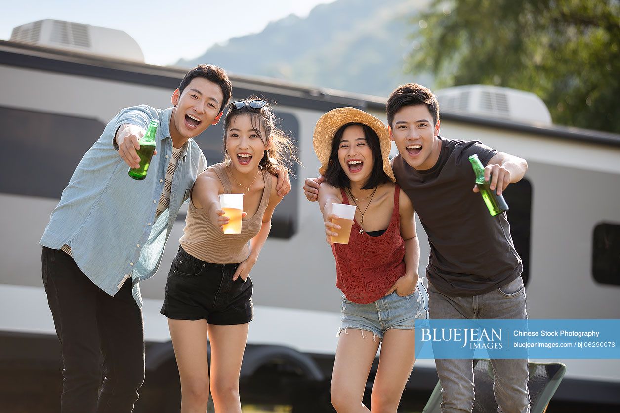 Happy young Chinese friends having a picnic outdoors