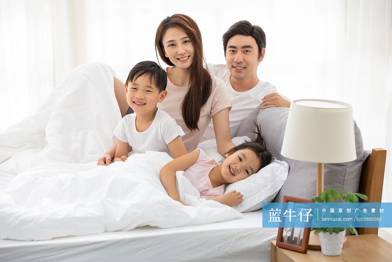 快乐的年轻家庭在床上