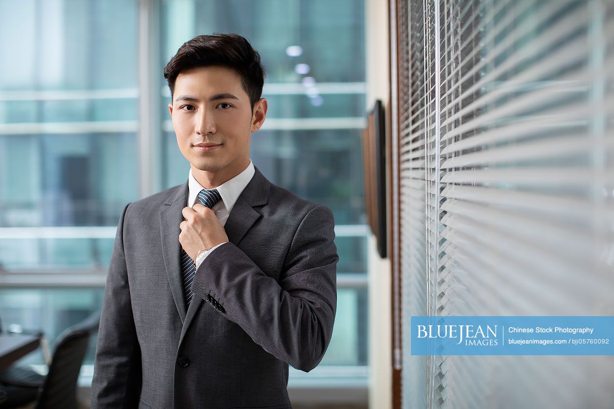 Confident Chinese businessman in office