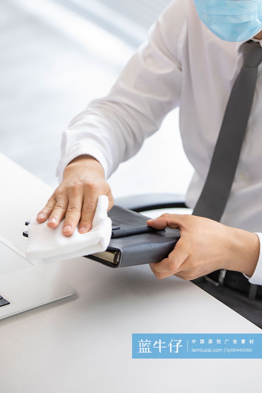 年轻的商务男士在办公室使用消毒液杀菌消毒