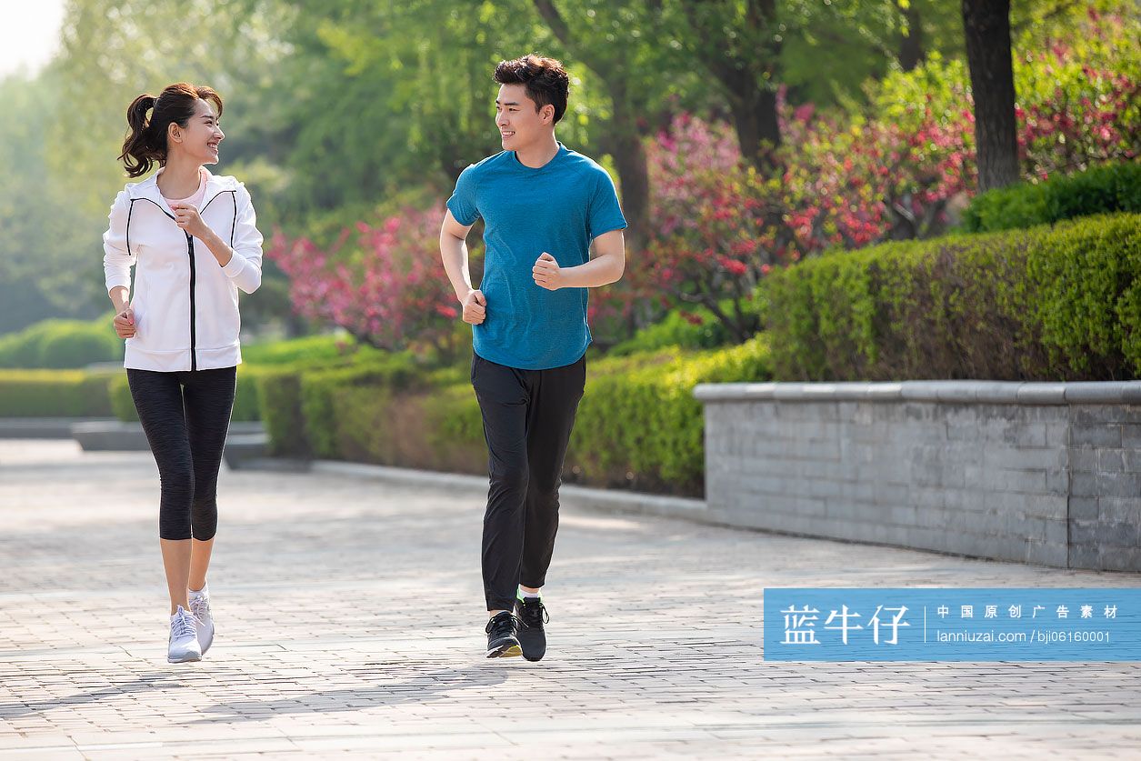 快乐的年轻情侣在公园跑步