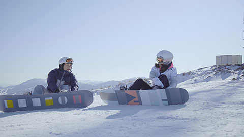 Young Chinese couple with snowboards on the snow,4K